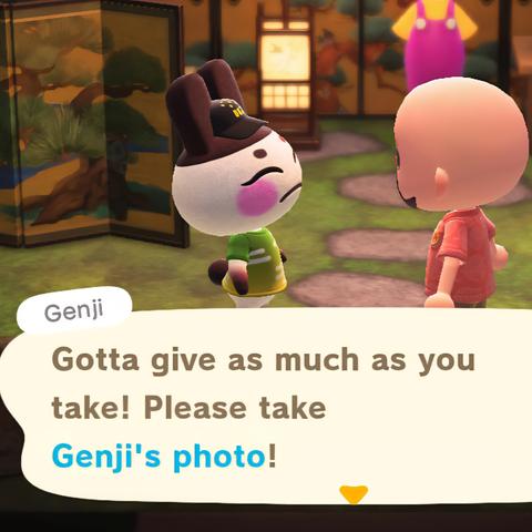 Animal Crossing: New Horizons screenshot set in Genji's house. Genji (white deer with brown ears and pink, rosy cheeks) is smiling broadly and talking to a bald, light skinned, bearded human wearing a pink shirt. The house has a swampy floor and golden screen walls. A Wario costume can be seen in the distance. Genji is saying in a large text box, "Gotta give as much as you take! Please take Genji's photo!"