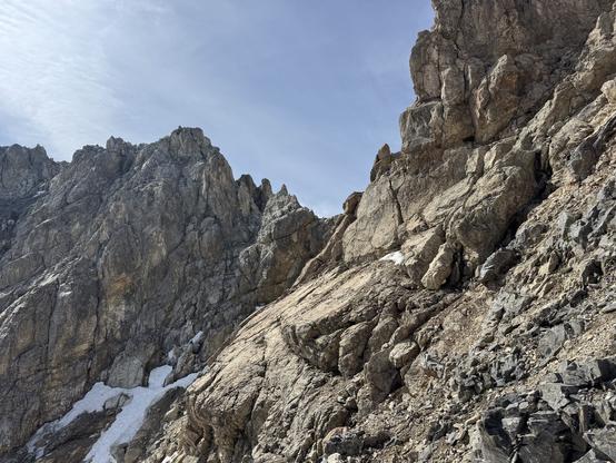Brownish rock slabs leading towards the ridge near Piz digl Gurschus main summit. Brittle rocks, a couloir with traces of snow left.