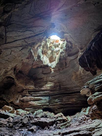 A cave with daylight coming through a hole in the roof 

Daylight Cave, Willi Willi National Park