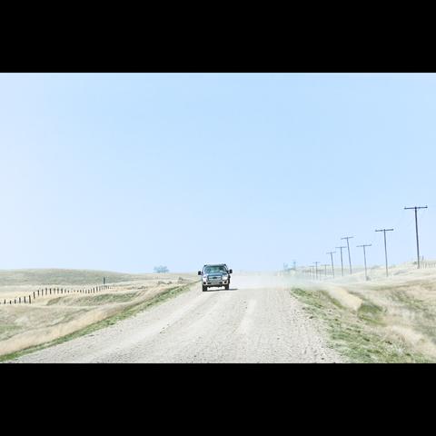 In the grasslands national park, Saskatchewan, Canada, a car with dust on a road