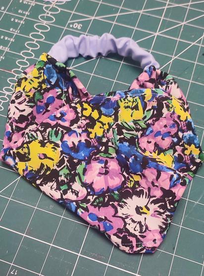 A head elastic bandana, with a floreal pattern. Main colors are pink, yellow blue and green.