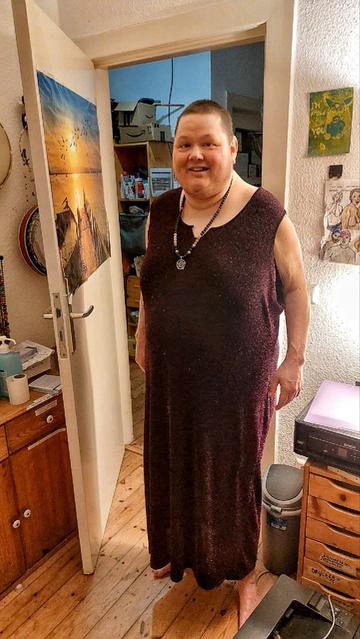 Me standing in the doorway wearing a black glittery dress and a pentagram pendant with pink and black crystals.