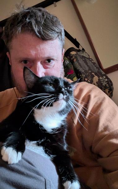 Selfie with tuxedo cat on my lap, she's making a funny serious expression