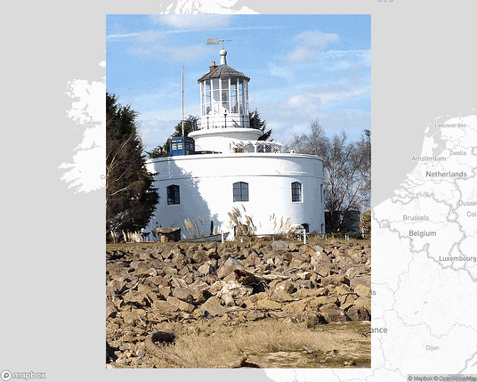 A photo of a lighthouse from the linked website, overlaid on a cropped world map where it's located.