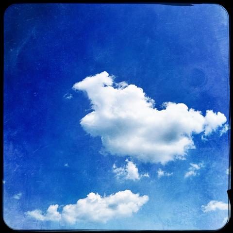 A bright blue sky with various fluffy white clouds scattered throughout.