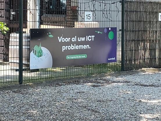 Reclamebord naast een petanquepleintje, van ICT bedrijf Wortell: 
Voor al uw ICT problemen