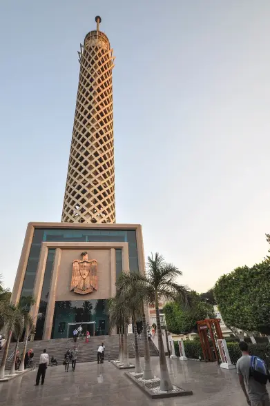 This image features the Cairo Tower, a prominent landmark in Cairo, Egypt. The tower is known for its distinctive design and is one of the tallest structures in the city. It typically features a viewing deck at the top that offers panoramic views of Cairo. The area around the tower appears to have a manicured landscape with palm trees and visitors walking nearby.

Image Credits: Wikimedia / Jorge Láscar from Melbourne, Australia / CC BY 2.0