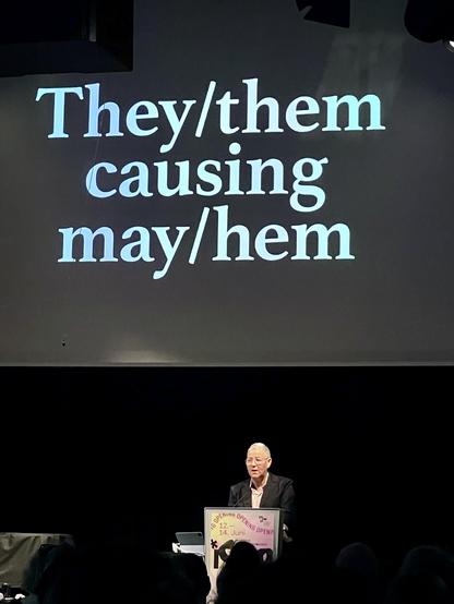 Picture shows a presentation slide stating „They/them causing may/hem“, with lecturer Jack Halberstam standing below the projection screen.