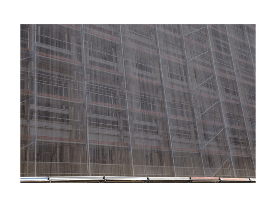scaffolding on a building in lisbon with semi see through mesh fabric. shot taken from an odd angle, picture runs out of balance in top right corner.