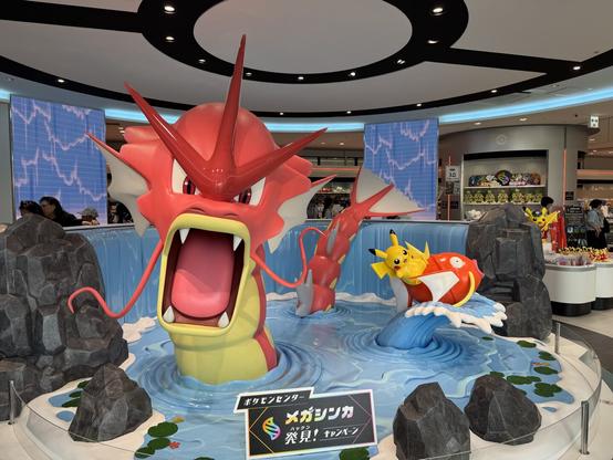 Shiny red Gyrados with Picachu riding a Magikarp.