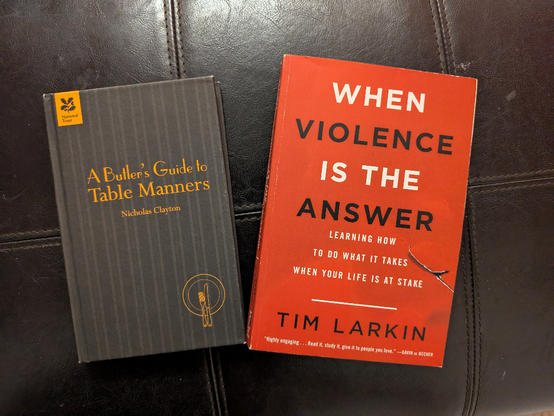 two books are shown,  one 'the butlers guide to table manners' the other "When violence is the answer"