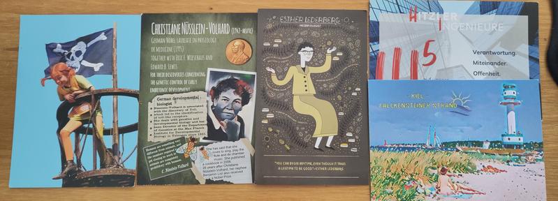 5 Postkarten. Einmal Pipi Langstrumpf, zwei mit Wissenschaftlerinnen, eine mit einem Strandmotiv aus Kiel und eine Werbekarte.