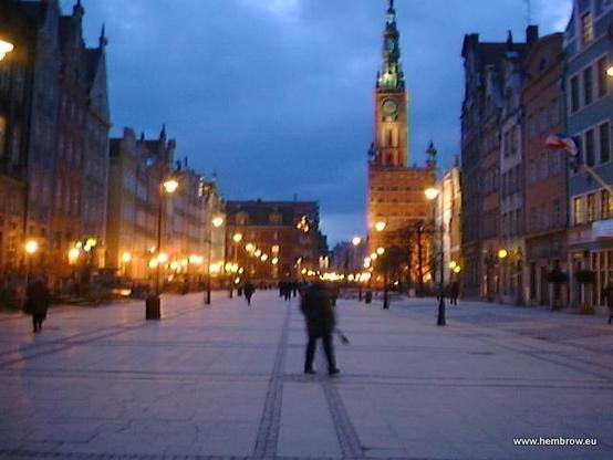 Gdansk is a beautiful city. Here a scene of an open square with a tower in the background.
