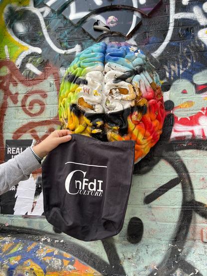Die NFDI4Culture-Tasche wird vor eine bunt gestaltete Wand mit einer plastisch gestalteten Oberseite eines Gehirns gehalten.
London, Shoreditch
CC0
Foto: Martin Albrecht-Hohmaier