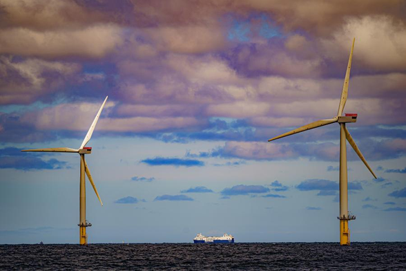 Two offshore wind turbines with a ship in between them