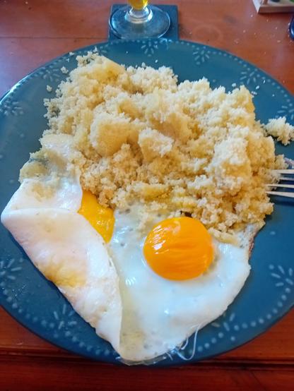 2 œufs sur le plat et semoule de couscous dans une assiette bleue