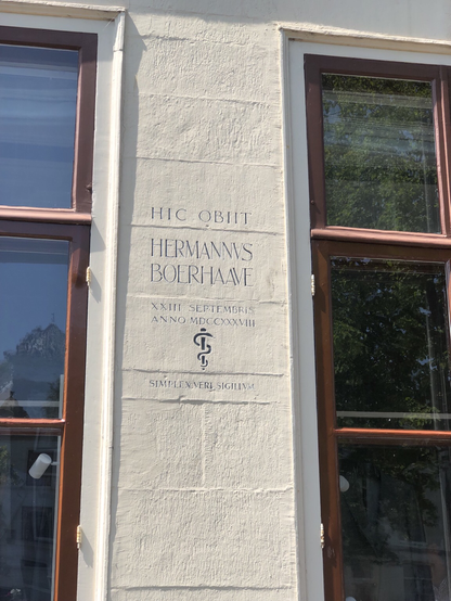 A photo of a Latin text painted on the wall of a townhouse on the Rapenburg canal in Leiden:

Hic obiit
Hermannus Boerhaave
XXIII Septembris
anno MDCCXXXVIII

Simplex Vero sigillum (which actually means ‘simplicity is the sign of truth’. Also he was actually a physician.)