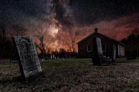 An old church and its graveyard, seen here under a starry night sky, are all that remains of the ghost town of Altona, Ontario.