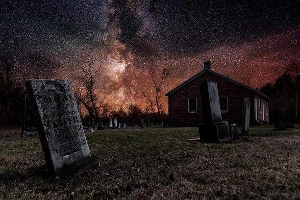 An old church and its graveyard, seen here under a starry night sky, are all that remains of the ghost town of Altona, Ontario.