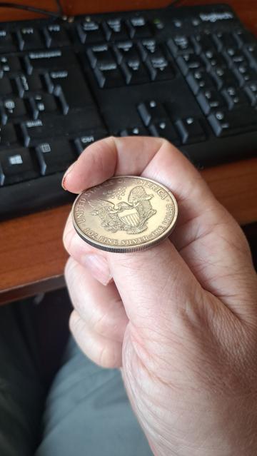 I'm flicking a "coin" to decide heads or tales. The coin in question, however,  is a solid silver 1oz Bullion "Silver Eagle" dollar