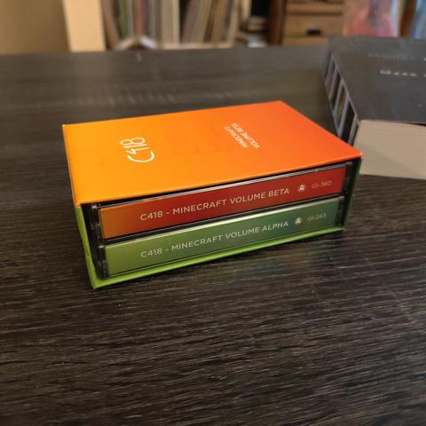 A two pack of cassettes that are both volumes of the Minecraft soundtrack by C418 in a nice, hard sleeve that is color matched to the green and orange of the cassettes themselves.