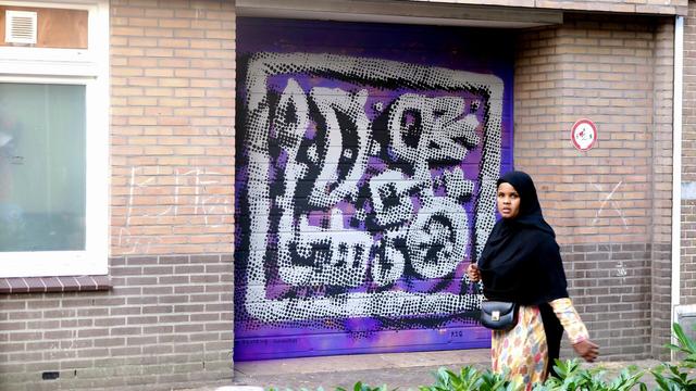 Painting on wall with woman in front