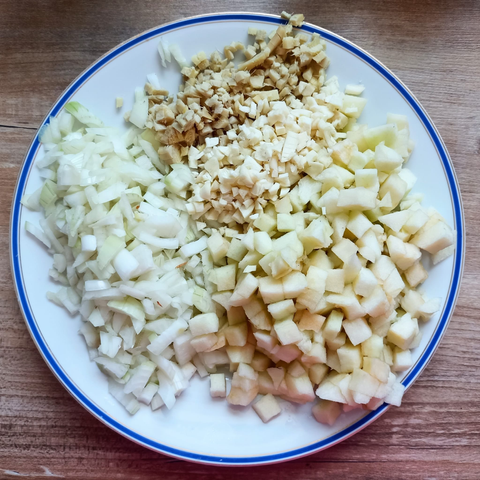 Auf einem Teller geschnitten: Zwiebel, Apfel, Knoblauch + Ingwer