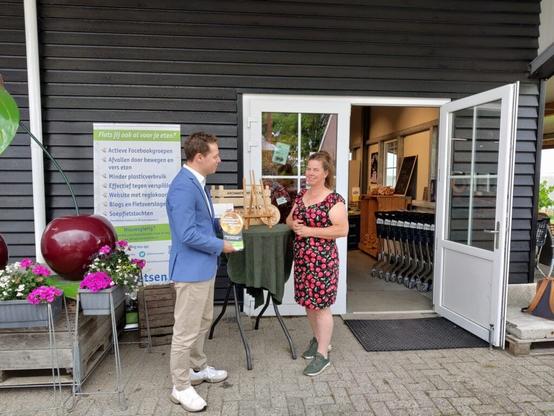 Onno reikt een award uit aan Eveline Westeneng, eigenaar van boerderijwinkel De Achterdijk,