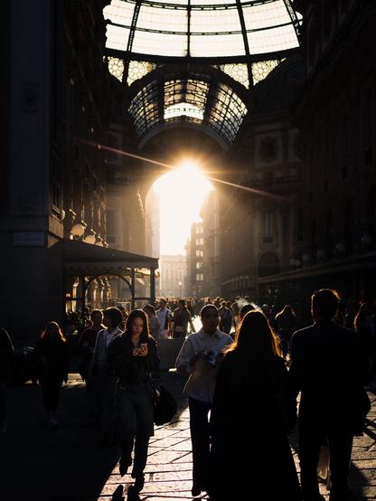 Sunset light coming through the Galleria Vittorio Emanuele II in Milan, illuminating the crowd.