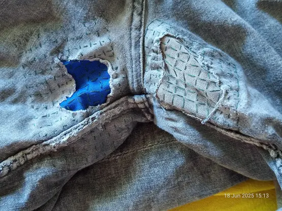 2nd pair of jeans with similar holes on the seat of the ass, but these 2 are smaller than the ones in the 1st photo. One patch is the same bright blue, while another is of a similar grey to the rest of the jeans. Both patches are anchored down with a slightly wonky grid of stitches, running mostly parallel to the central and inner thigh seams. Again, the edges of the holes are quite freyed but if I have to cut away any more of these jeans they're not going to be patchable. Grey denim with dark forest green stitches
