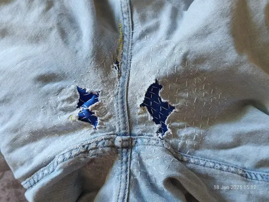 3rd seat-of-the-ass jeans photo. This time the holes are much smaller, but the overall area covered in stitches is much bigger. These jeans are desperately trying to dissolve into confetti but I won't let them. Pale denim with white stitches