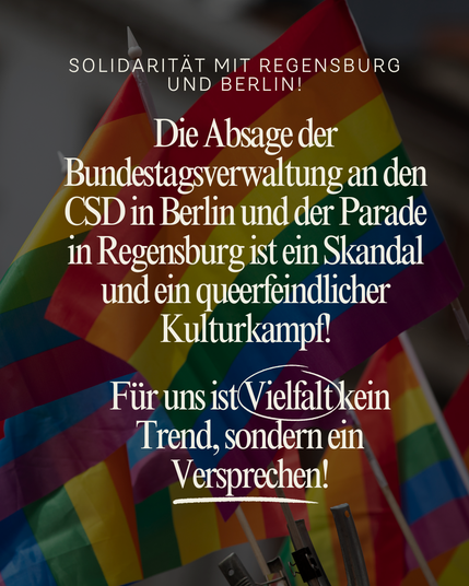 Hintergrundbild mit mehreren wehenden Regenbogenflaggen.
Darüber weißer, zentrierter Text:
„Solidarität mit Regensburg und Berlin!
Die Absage der Bundestagsverwaltung an den CSD in Berlin und der Parade in Regensburg ist ein Skandal und ein queerfeindlicher Kulturkampf!
Für uns ist Vielfalt kein Trend, sondern ein Versprechen!“
Das Wort „Vielfalt“ ist handschriftlich eingekreist, „Versprechen“ ist unterstrichen.
Der Text wirkt kämpferisch und entschlossen – vor dem Hintergrund der bunten Flaggen steht er symbolisch für Widerstand gegen queerfeindliche Politik.