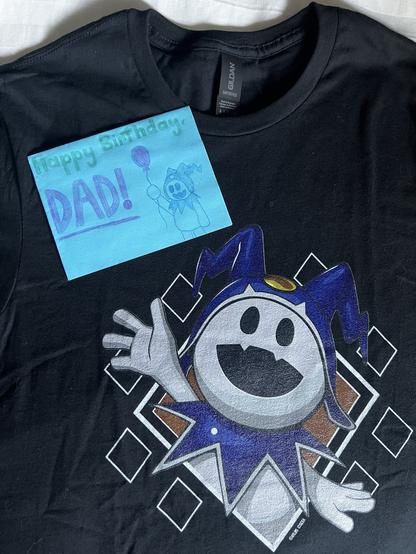 Hand-drawn birthday card with Jack Frost holding a balloon on top of a black t-shirt featuring a big image of Jack Frost.