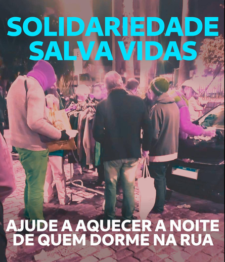 Fotografia de um grupo de 6 pessoas agasalhadas, agrupadas em torno de uma arara de roupas no que parece ser uma praça.

Sobre a foto, em letras garrafais: Solidariedade salva vidas.
E abaixo: "Ajude a aquecer a noite de quem dorme na rua."