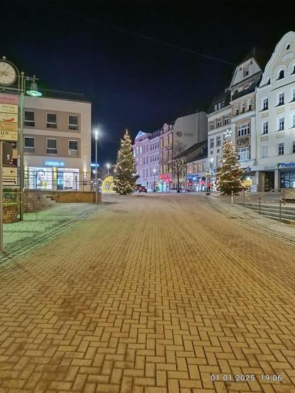 City street decorated for Christmas at night.