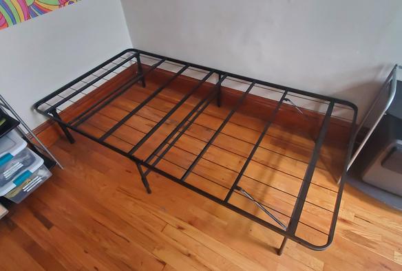 Twin size bed frame set up in a room.