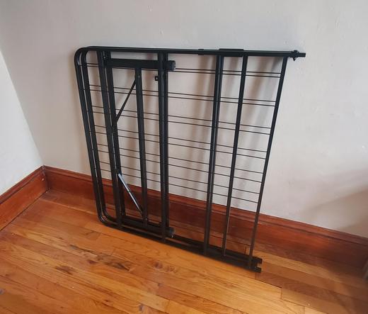 Twin size bed frame, folded and leaning against a wall.