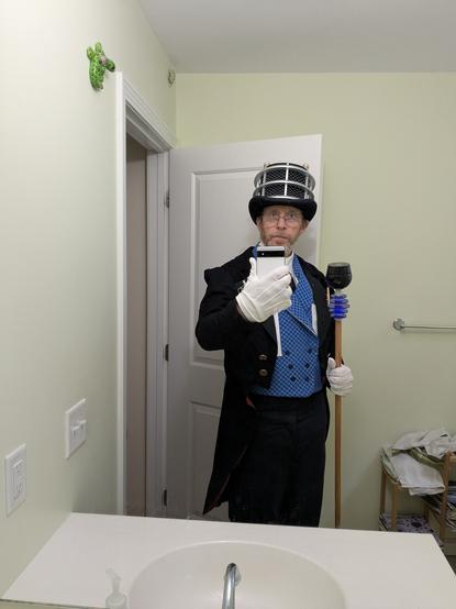 A man wearing tails, a waistcoat, a top hat and carrying a walking stick all carrying the design language of a Dalek