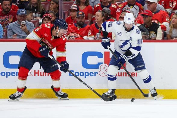 Florida Panthers center Carter Verhaeghe (23) and Tampa Bay Lightning right wing Nikita Kucherov (86) battle for the puck in the first period during game three of the first round of the 2025 Stanley Cup Playoffs at Amerant Bank Arena.
