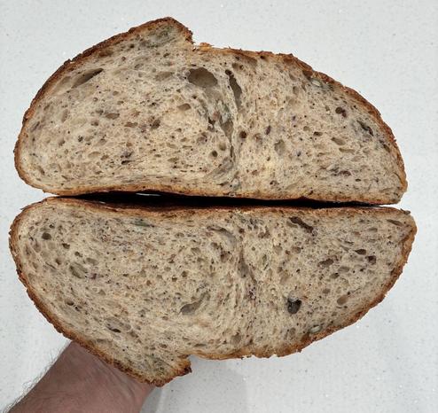 Crumb shot of seeded sourdough showing texture, seeds and sage.