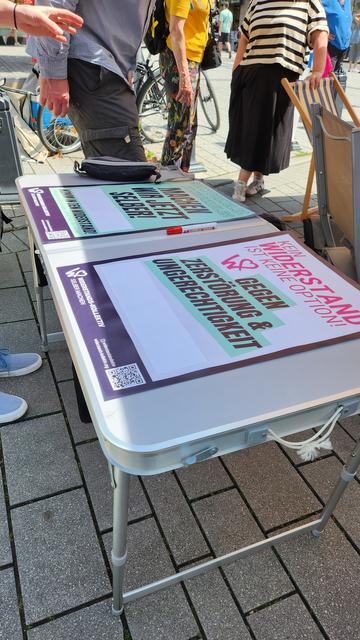 Plakate des Widerstandskollektivs in der Nahaufnahme. Darauf steht: Gegen Zerstörung ung Ungerechtigkeit.