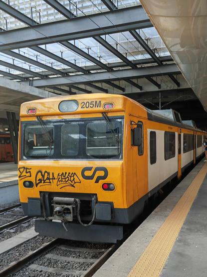 An ageing diesel unit in pale orange Comboios de Portugal livery