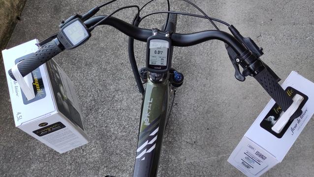 Vélo vert vu du dessus avec une boîte de litière accrochée de chaque côté du guidon