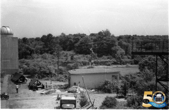 Archival photo of the Westport Observatory with guys climbing a light pole to hang an antenna