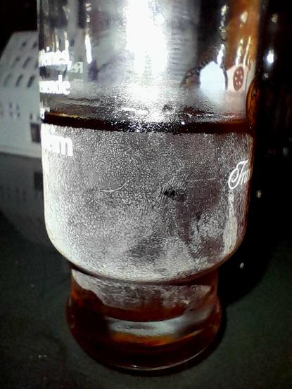 Frost condenses on a small glass filled with subzero Mümmelman, a Jägermeißter analog.