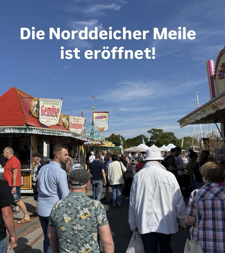Viele Menschen laufen über den Kunst- und Handwerkermarkt mit vielen bunten Ständen in Norddeich. Der Himmel ist blau und die Sonne strahlt