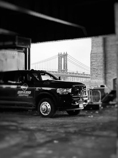 A truck parked in a construction area by the East River. In the distance is the Manhattan Bridge