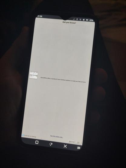 A humorous photo of LibreOffice Writer loaded on a OnePlus 6T phone running PostmarketOS Linux. The applications 'tip on startup' fills the entire screen, and says "LibreOffice offers a variety of user interface options to make you feel at home"