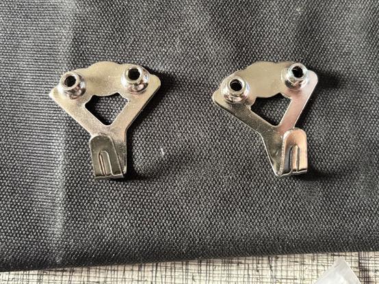 Two little hooks for hanging stuff on the wall that look like they have faces and huge grinning mouths.