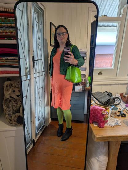 Mirror selfie of me wearing the green stockings outfit shown in the flat lay.